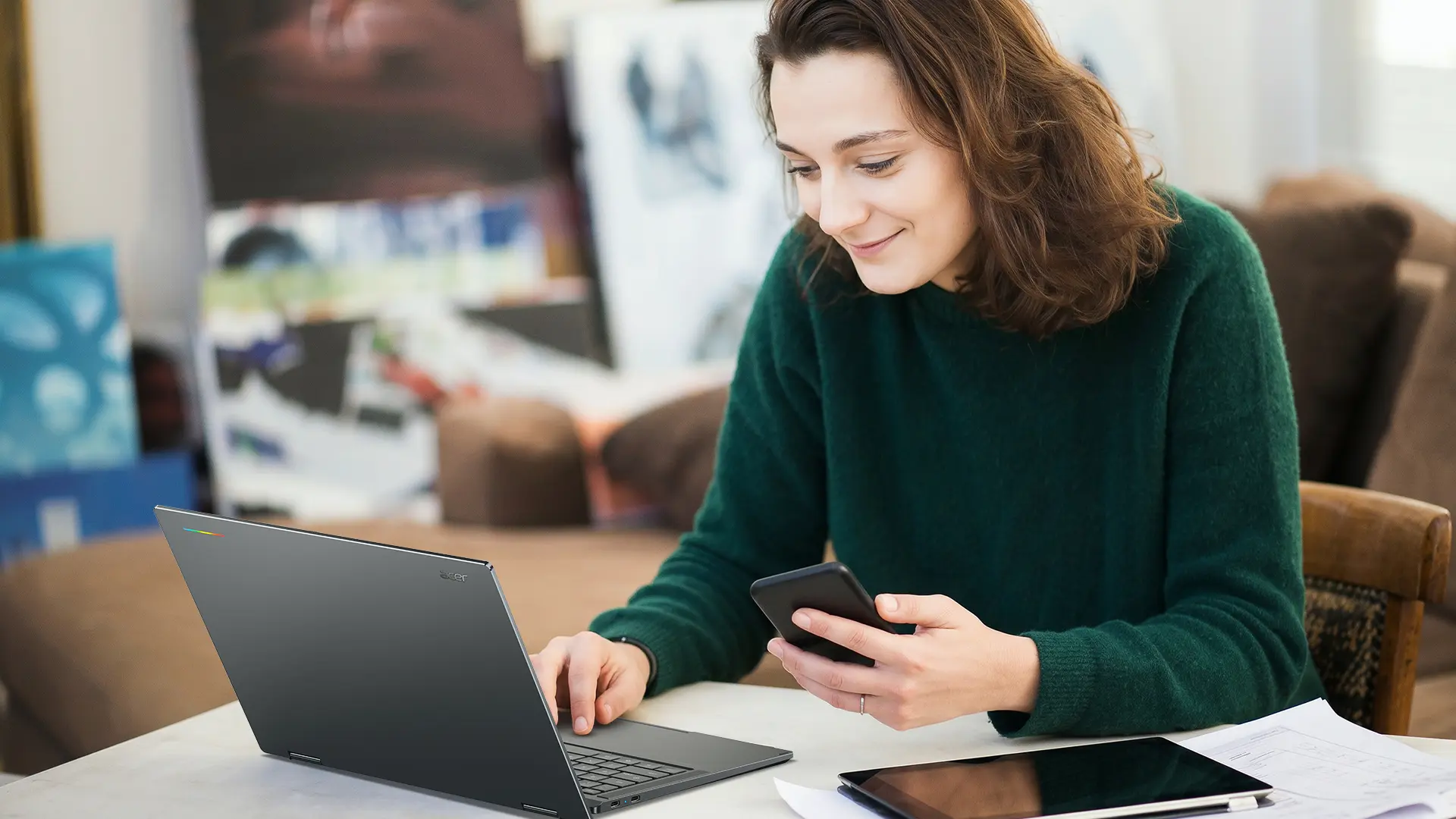 Person using an Acer Googlebook 14 laptop alongside a smartphone and tablet